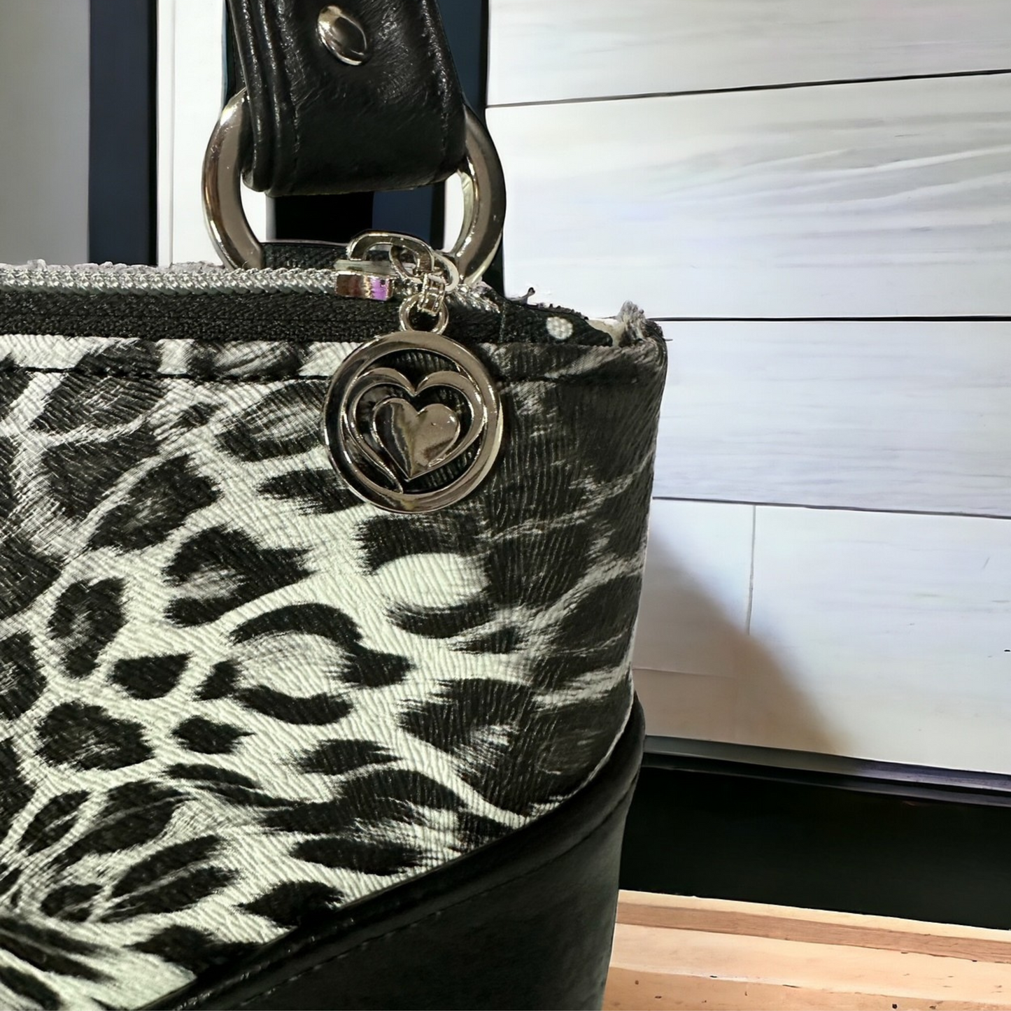 Trendy Black Leopard Handbag – Features a Durable Vinyl Exterior, Faux Leather Accents, Water-Resistant Canvas Lining, and Secure Zip Closures with Heart Pulls