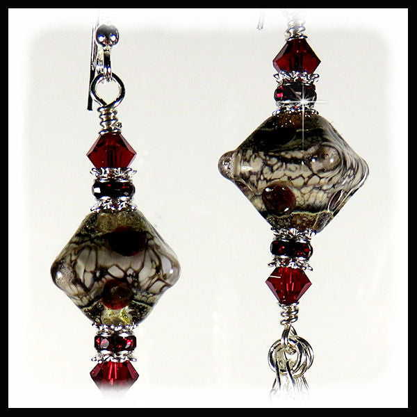 The artisan handmade murano glass beads are a mixture of tan and gray with circles of red