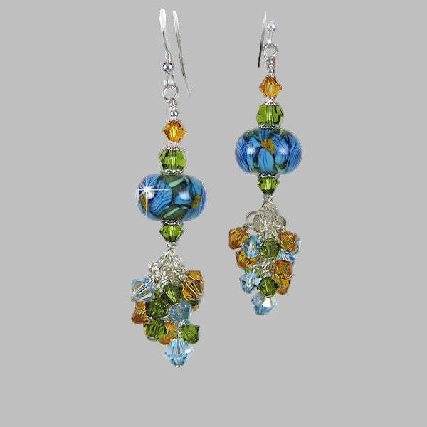 Stunning artisan handmade lampwork earrings with a cluster of topaz, light sapphire and olive green Swaorvski crystals dangling below. 2.5" dangle