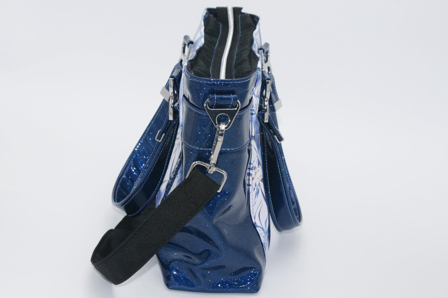 the side of the blue glitter vinyl tote bag showing the crossbody connectors.