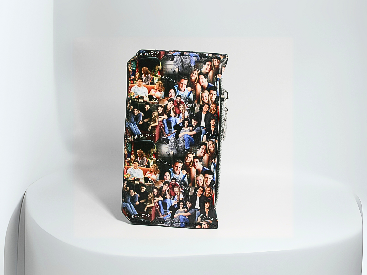 The back of the FRIENDS central perk-themed Purse Pal slim wallet featuring a snap flap closure to securely hold credit cards. Designed with six card slots, a cash slip pocket, and a zippered coin pocket. Accented with a Central Perk zipper pull, silver hardware, and a compact, stylish design. A must-have accessory for fans of the classic sitcom who love functional and trendy wallets.