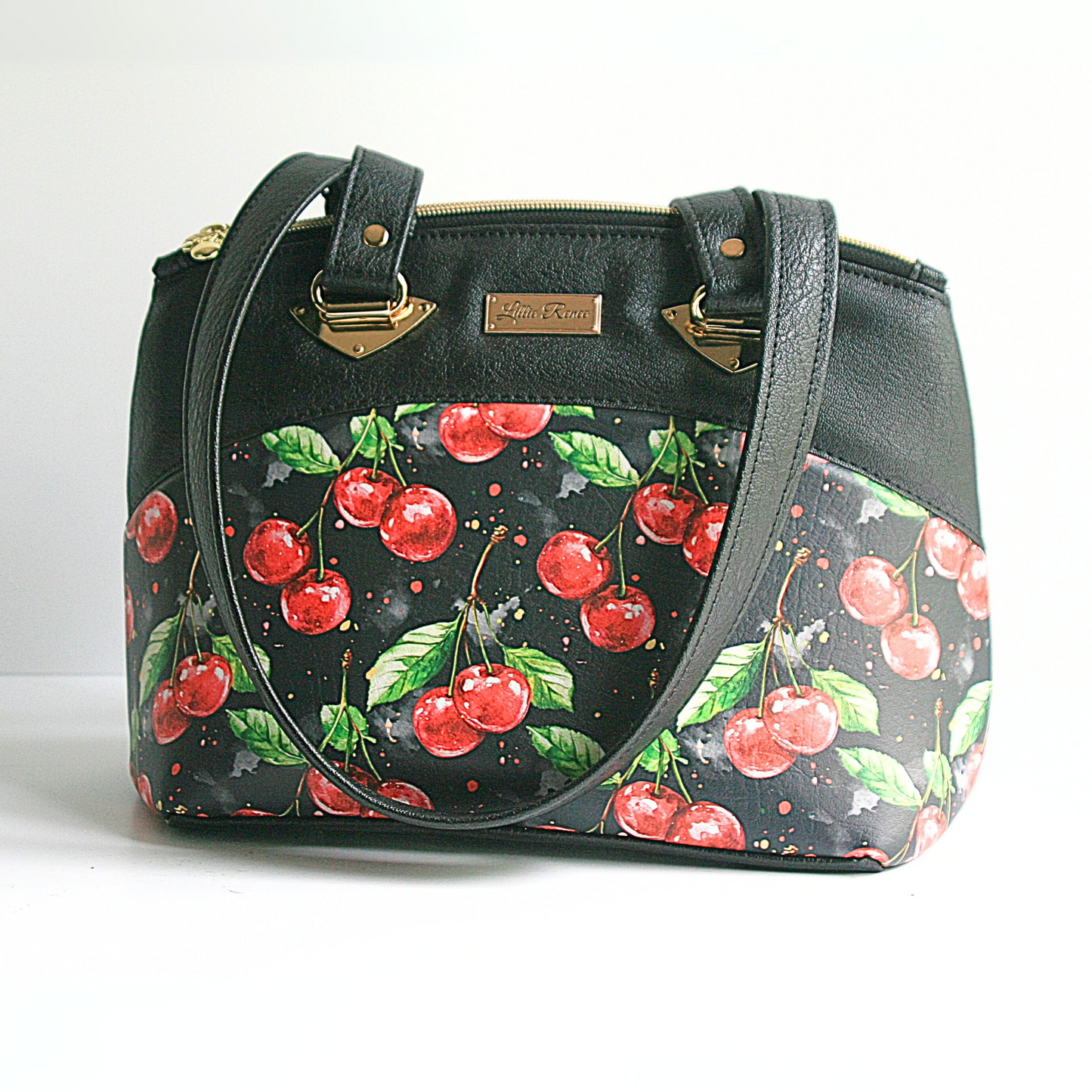 A medium to large shoulder bag with the Cherries Jubilee vinyl and gold hardware