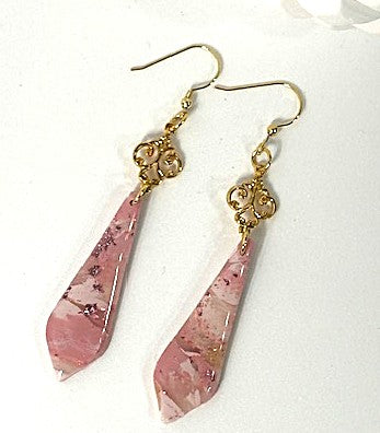 Pink teardrop earrings with gold hooks on a white background