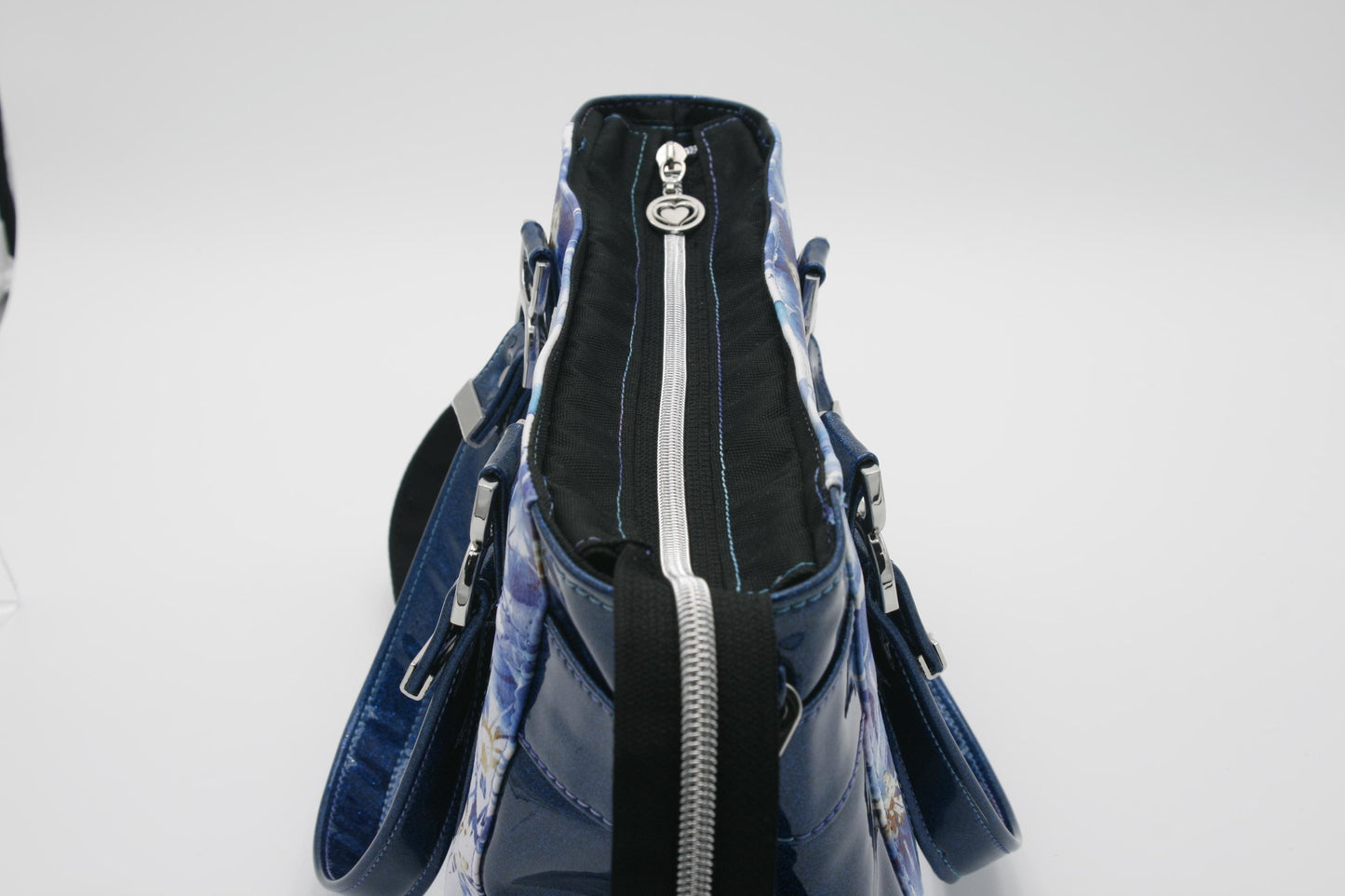 showing the top zipper closure of the bag with the double heart zipper pull and glitter vinyl