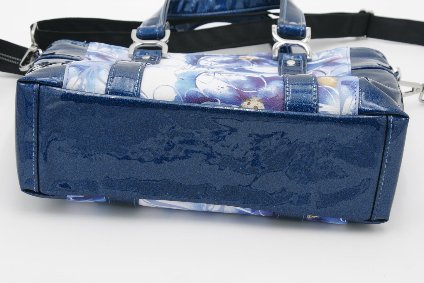 showing the bottom of the blue floral tote bag which is the blue glitter vinyl