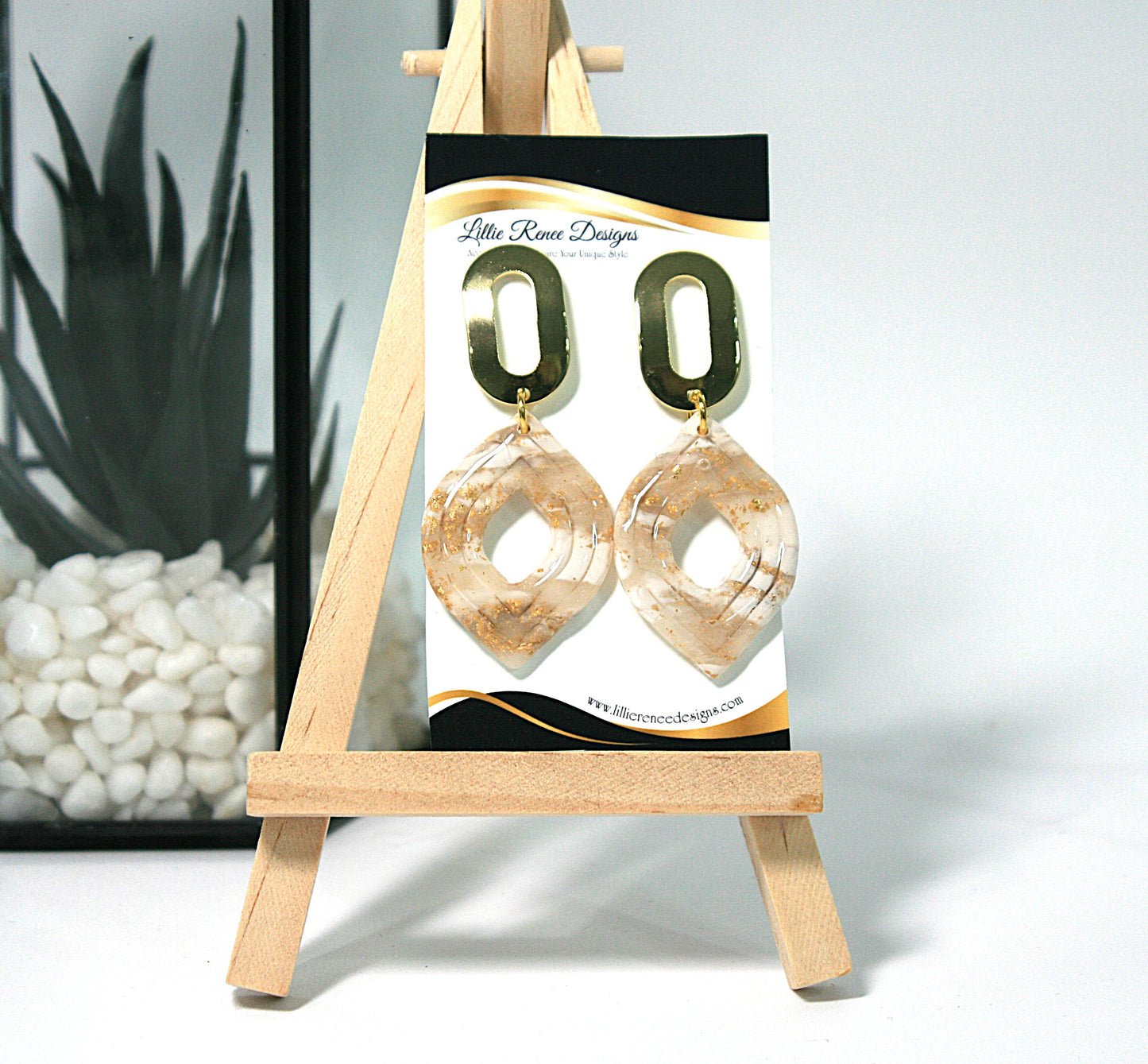 Pair of gold hoop earrings on a display card with 'Little Rose Designs' branding, placed on a small wooden easel.