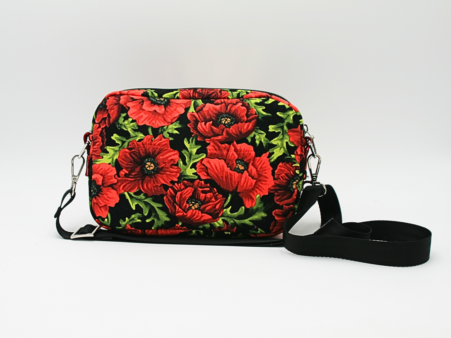 Vibrant red poppy floral fabric on a durable cotton woven exterior, beautifully accented with silver hardware and black nylon webbing strap.
2️⃣ Front View of the Crossbody