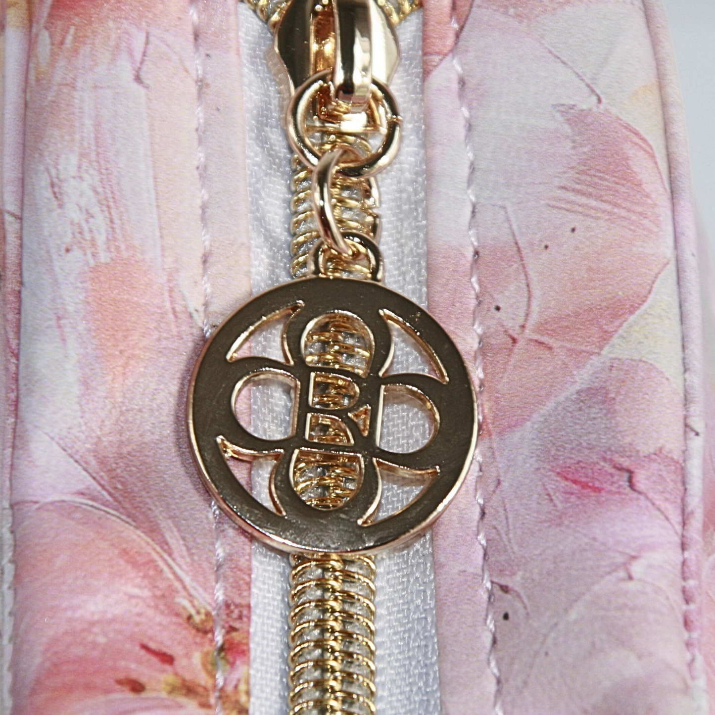 Pink floral crossbody purse with gold hardware and top zipper closure