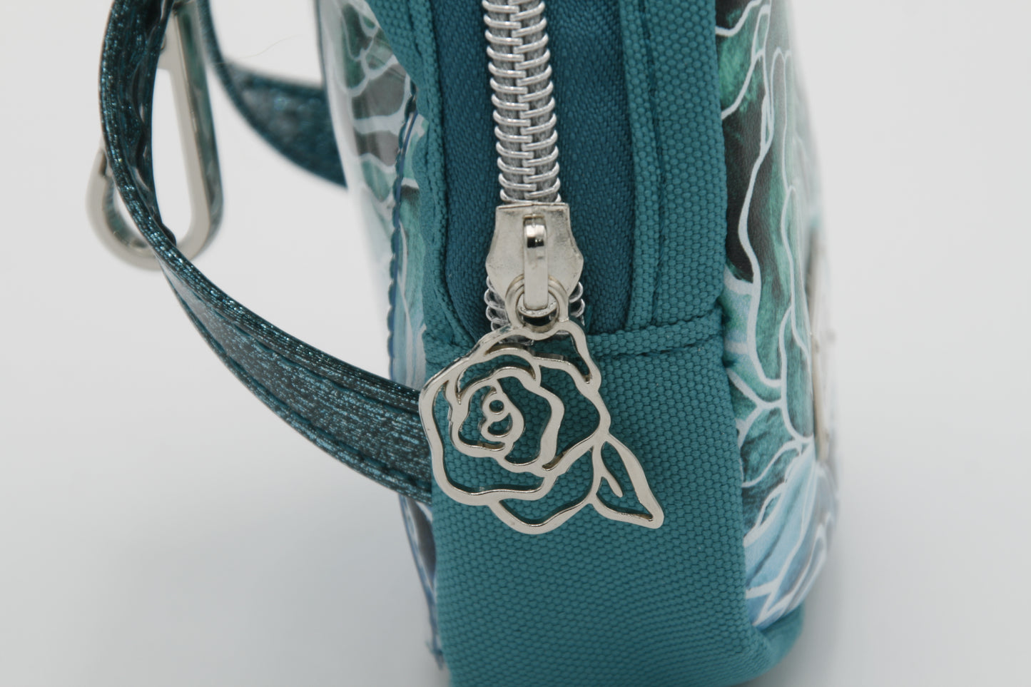 Teal bag with floral design and unique silver hardware