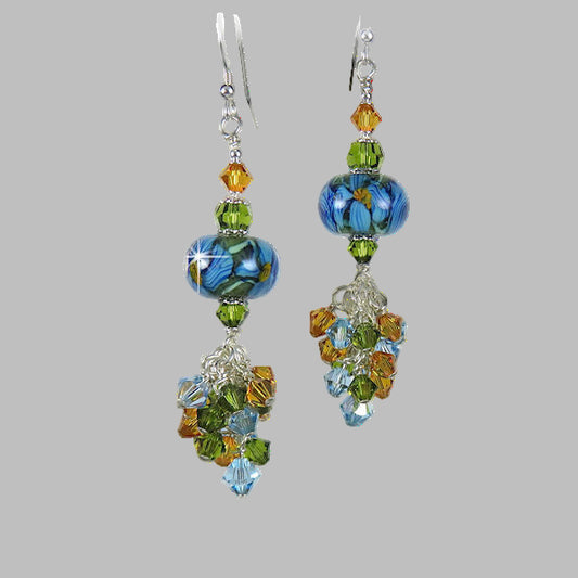 Stunning artisan handmade lampwork earrings with a cluster of topaz, light sapphire and olive green Swaorvski crystals dangling below. 2.5" dangle