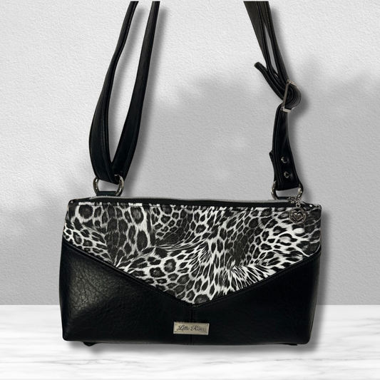 A front view of the  Handmade Black  Leopard Animal Print Crossbody Purse – Features a Black Leopard Vinyl Exterior, Adjustable Faux Leather Strap, and Silver Hardware for a Chic and Stylish Look.
