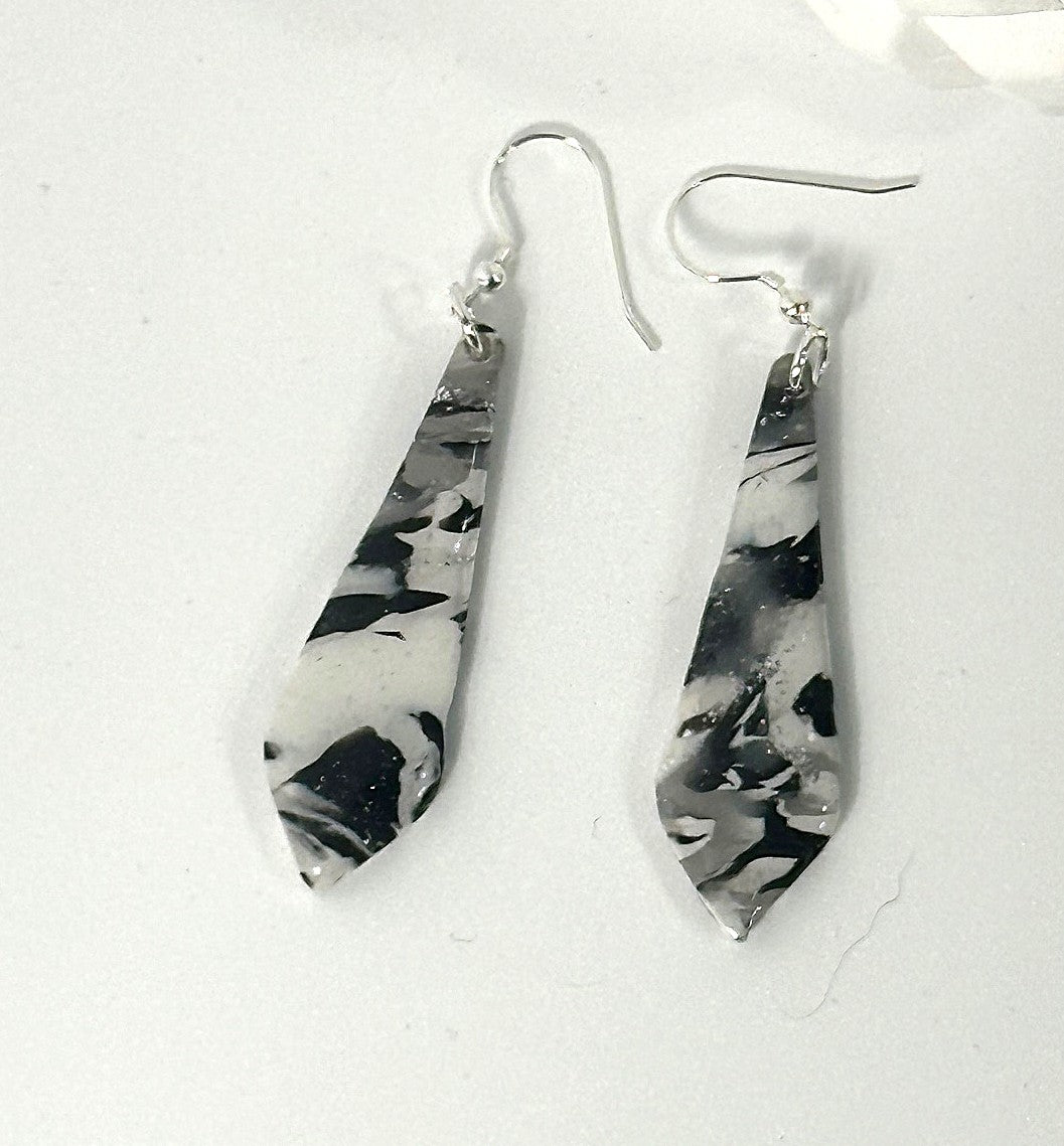 Pair of black and white marbled teardrop earrings on a white background