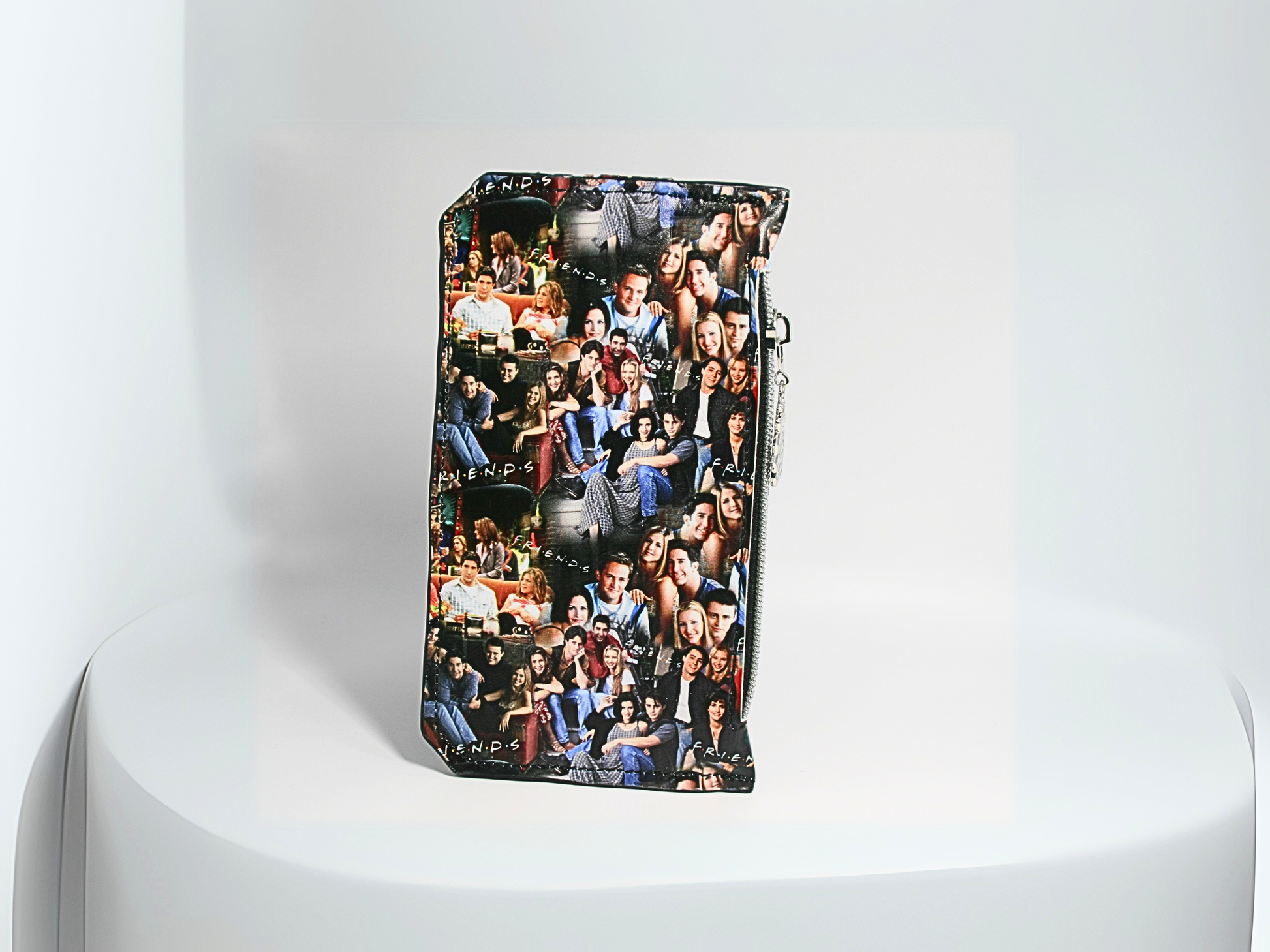  The back of the FRIENDS central perk-themed Purse Pal slim wallet featuring a snap flap closure to securely hold credit cards. Designed with six card slots, a cash slip pocket, and a zippered coin pocket. Accented with a Central Perk zipper pull, silver hardware, and a compact, stylish design. A must-have accessory for fans of the classic sitcom who love functional and trendy wallets.