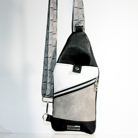 Front view of sling bag showing zipper pockets and webbing strap