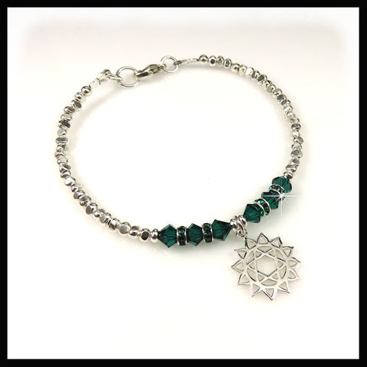 This bracelet features green swarovski crystals and a heart chakra-representing-compassion-and-love