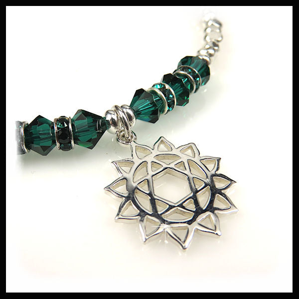 close up of the sterling silver heart chakra and emerald green swarovski crystals