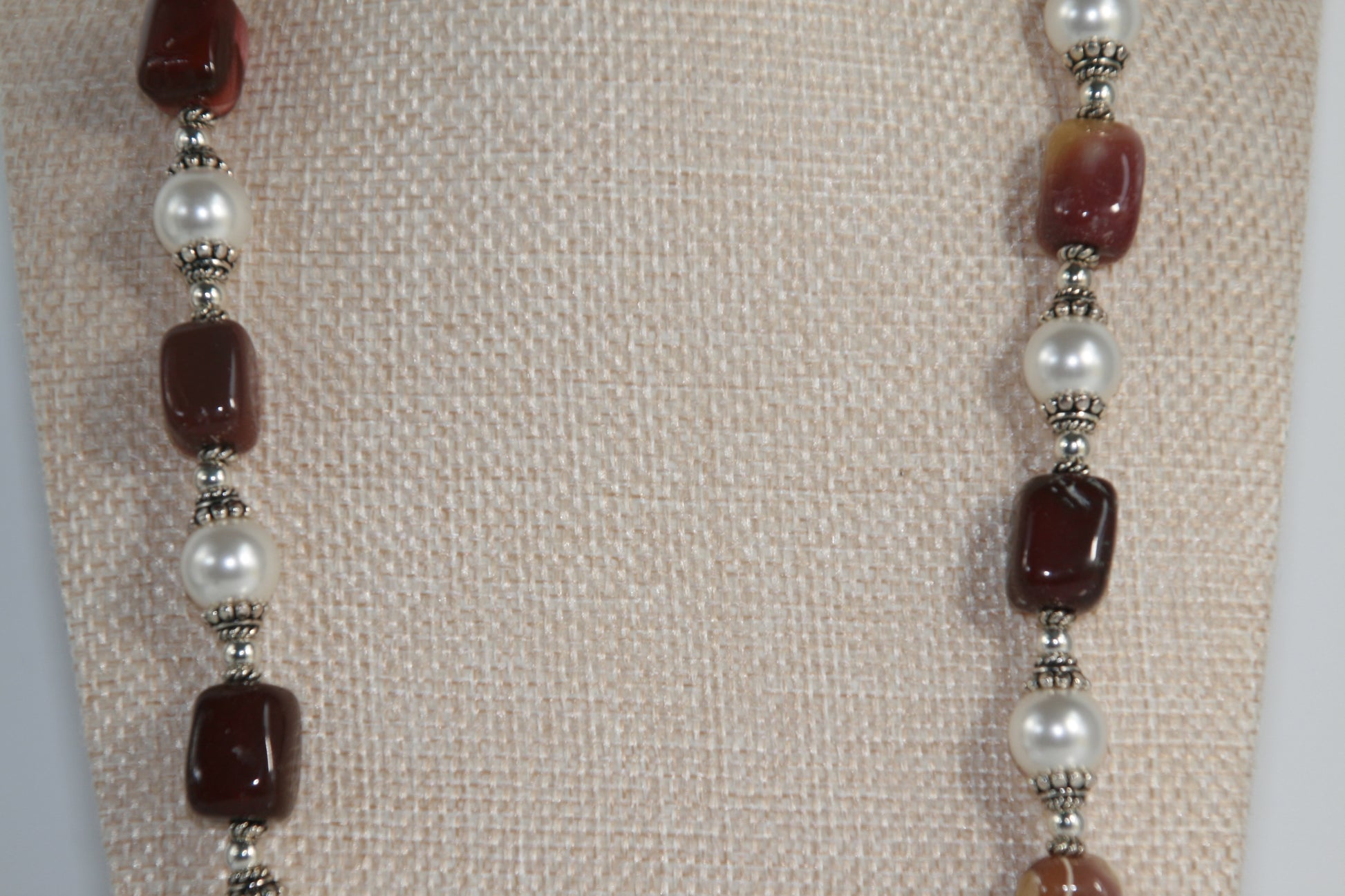 25-inch necklace featuring burgundy, mustard, and cream Mookaite gemstones, white Swarovski pearls, and sterling silver accents with extender chain.


