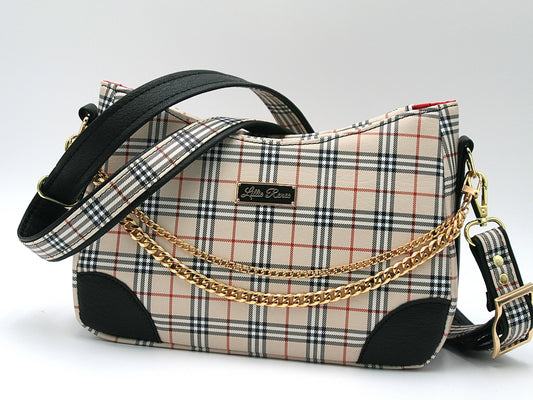 The Annabelle crossbody is designed with res, black and tan tartan plaid, This is the front of the bag which features a gold chain draped elegantly across the front.  