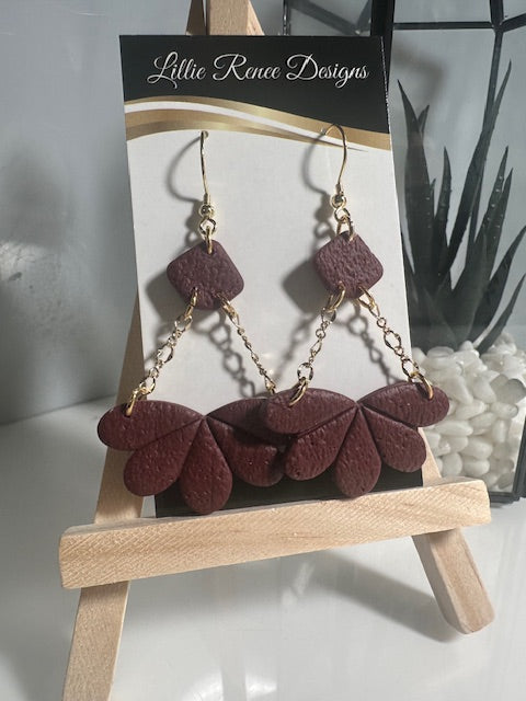Burgundy handmade polymer clay earrings hanging from 14k gold plated chain.