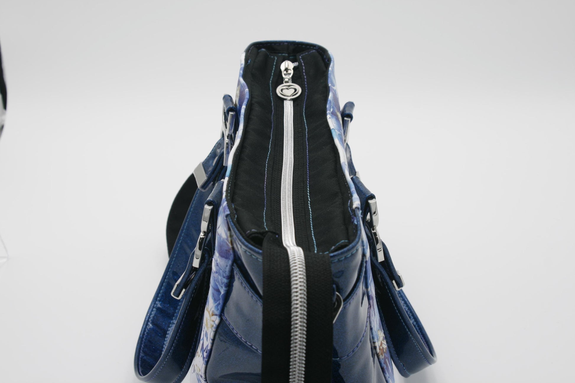 showing the top zipper closure of the bag with the double heart zipper pull and glitter vinyl