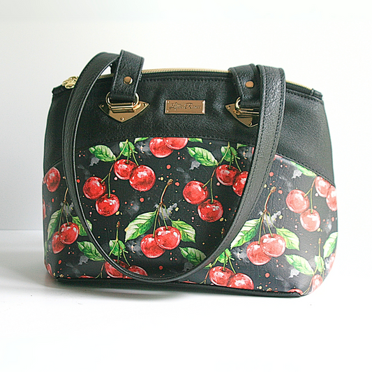 "Medium red handbag with cherry zipper pulls and interior zipper pocket