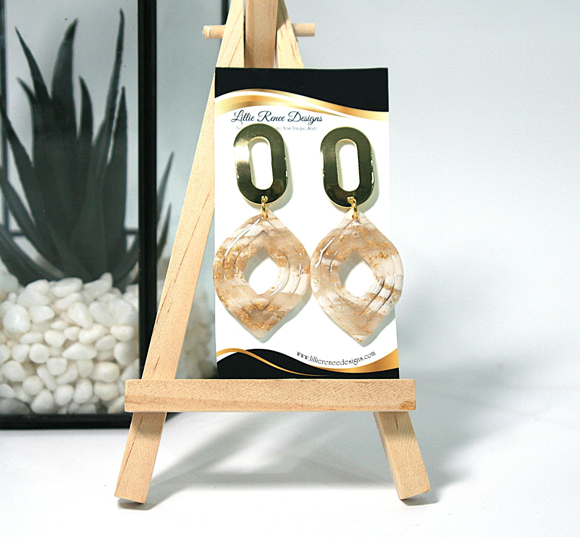 Pair of gold hoop earrings on a display card with 'Little Rose Designs' branding, placed on a small wooden easel.