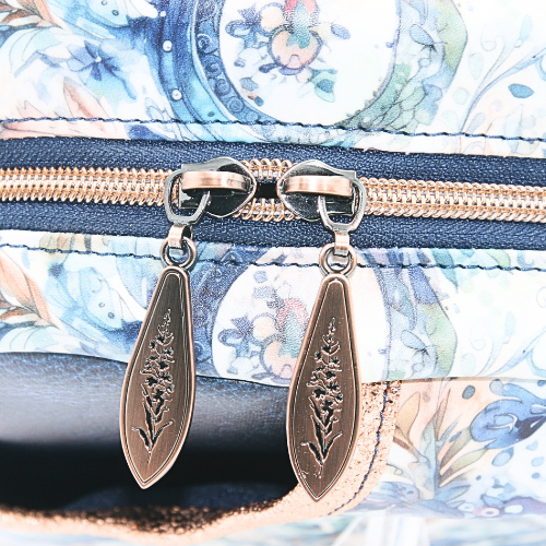 A top double brushed copper zipper closure for added security on the blue paisley sling