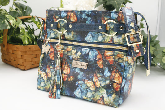 Vibrant watercolor butterfly print – A dreamy mix of blues, golds, and oranges on a durable, high-quality vinyl.
✔ Front zipper pocket with a stylish tassel  and two tone adjustable strap