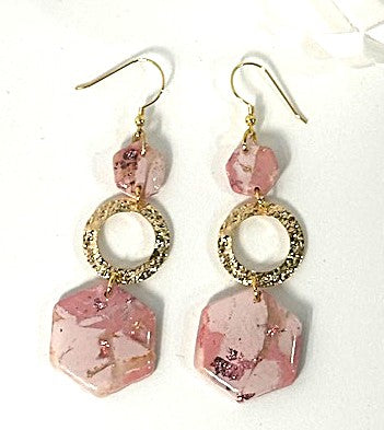 Pair of pink earrings with gold accents on a white background