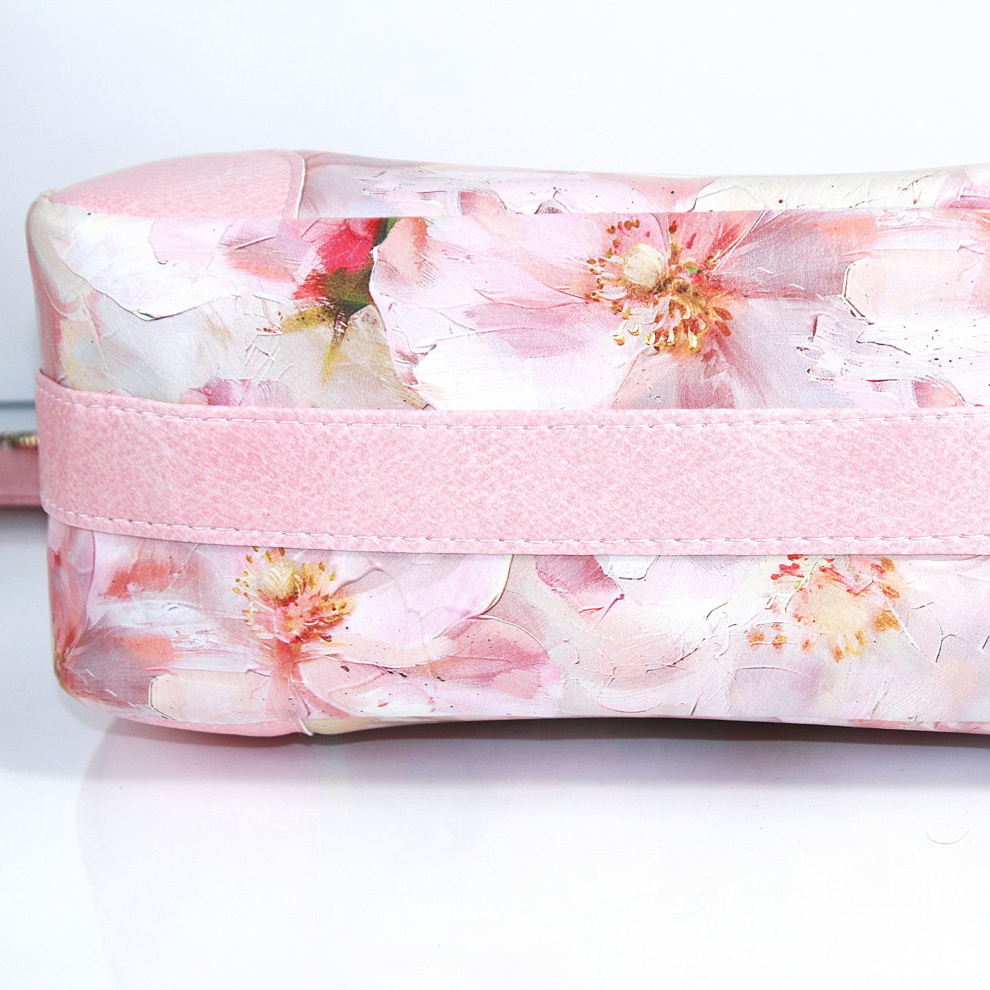 Feminine floral spring handbag in pink and gold tones.  Connector strap goes down around the bottom of the bag.