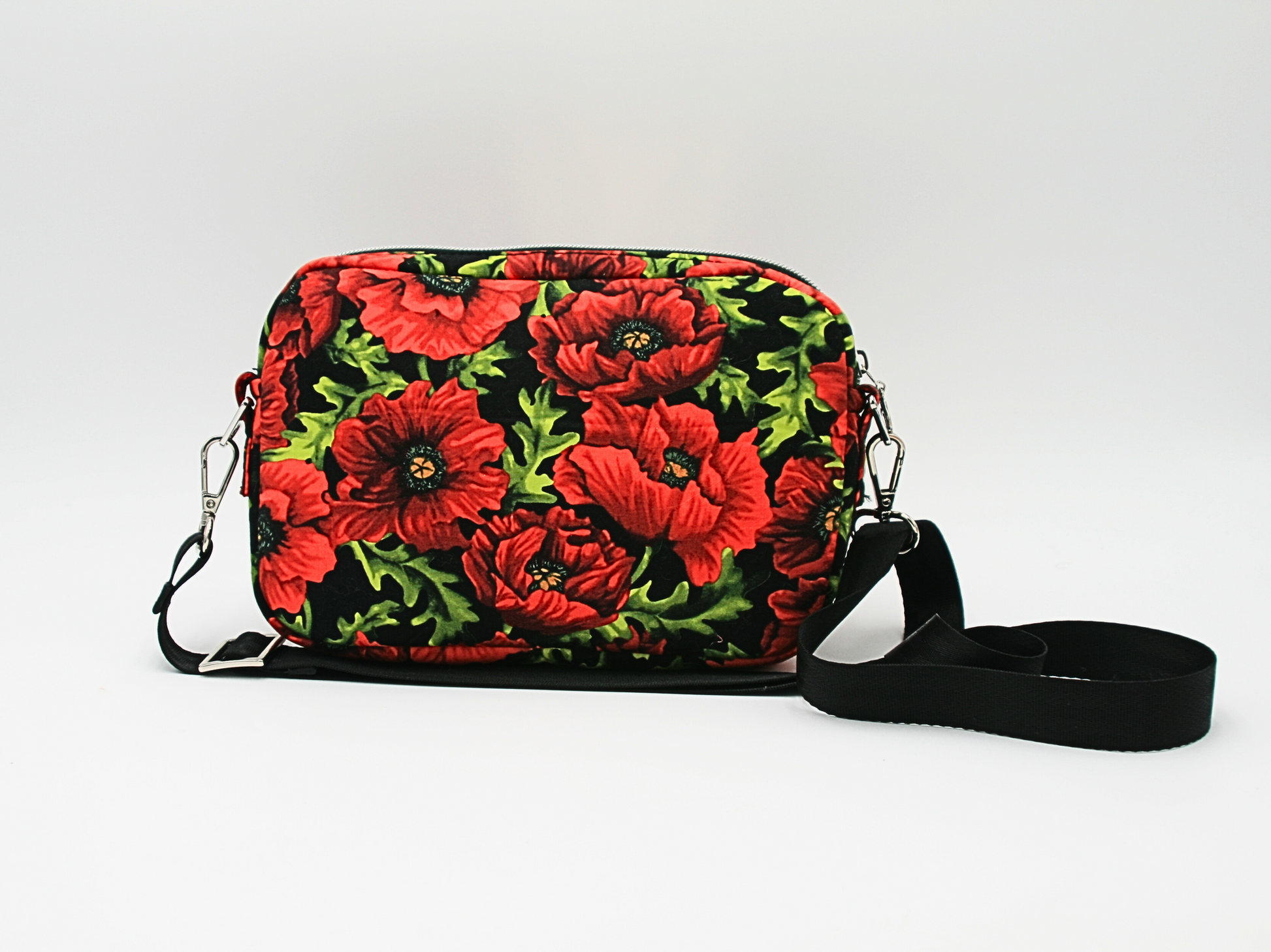 Vibrant red poppy floral fabric on a durable cotton woven exterior, beautifully accented with silver hardware and black nylon webbing strap.
2️⃣ Front View of the Crossbody