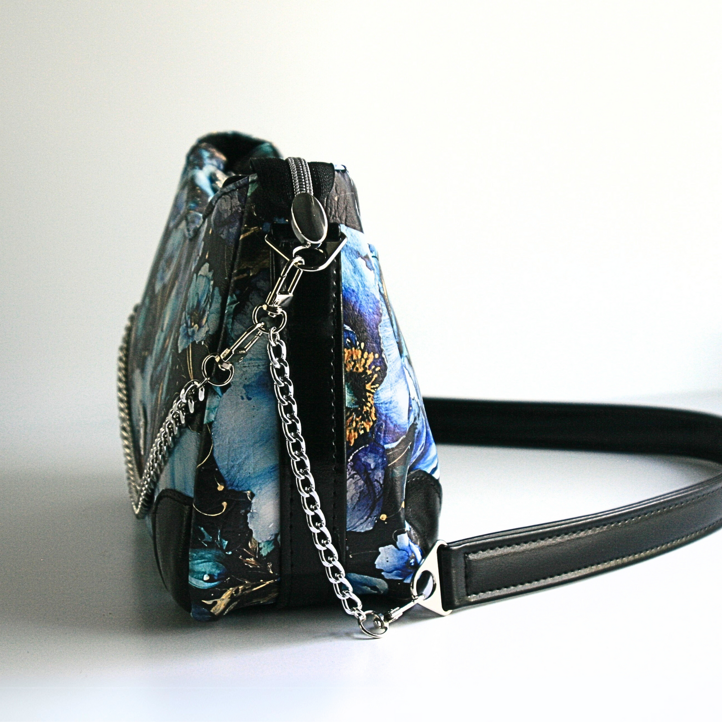 side of the blue poppies shoulder bag showing attached decorative chain andstrap