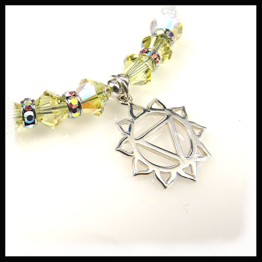 The sterling silver solar pkexus chakra charm hangs from a bracelet of yellow Swarovski crystals and sterling silver nuggets